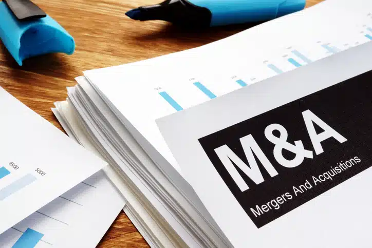 Photo of merger and acquisition documents. End2End Wins also provides M&A implementation services.